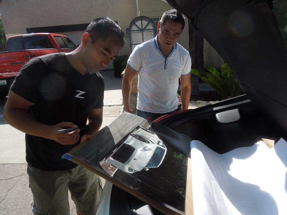 Randy Rodriguez signing a poster size shot of car for my office.