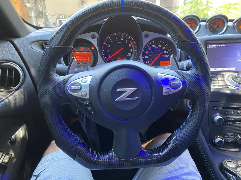 CF steering wheel with blue stitching and a blue center stripe