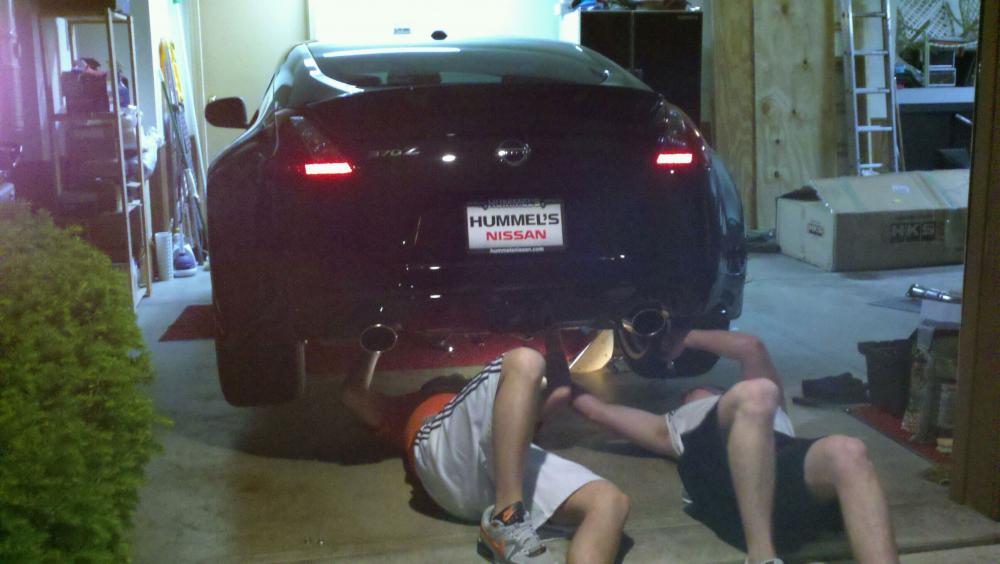 working on prying exhaust hangers off of the stock muffler.. I am on the left.